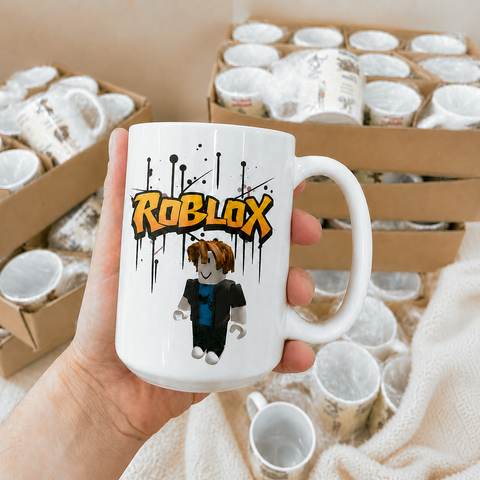 Біла чашка з принтом Roblox у руці на тлі запакованих чашок
